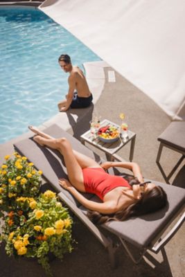 Two friends lounging by Fairmont Chateau Whistler pool
