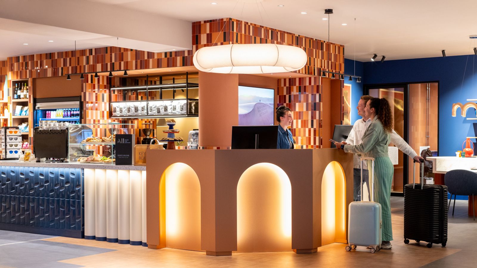 Un couple qui fait son check-in à la réception de l’hôtel TRIBE Hotel Den Haag Centraal