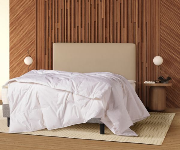 Mövenpick signature hotel duvet on a bed in front of a modern wooden headboard