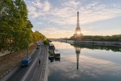 The golden sun rising behind the Eiffel Tower and the Seine in Paris