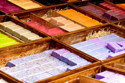 Colourful bars of Provence soap nestled in straw in wooden boxes at a market stall