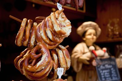 Des bretzels natures et garnis de fromage sont disposés sur l’étal d’un marché de Noël en Alsace