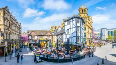 Pubs históricos de entramado de madera en una plaza concurrida de Mánchester
