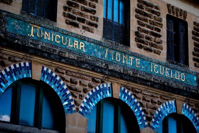 Edificio con cartel de "FUNICULAR MONTE IGUELDO" y arcos de azulejos azules