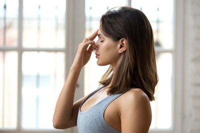 Junge Frau in der Yoga-Stellung Nadi Shodhana Pranayama bei Atemübungen