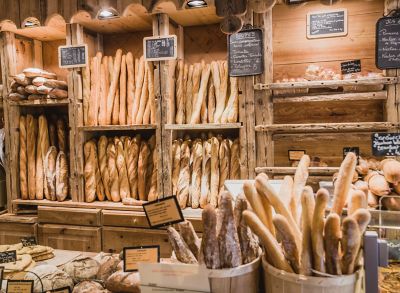 An assortment of baguettes and other baked goods in a rustic French boulangerie