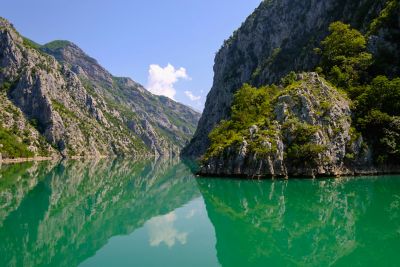 Craggy mountains lining the calm waters of Komani Lake in Shkodër, Albania