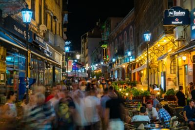 Nightlife-seekers in an illuminated, pedestrianised street in Bucharest's Old Town