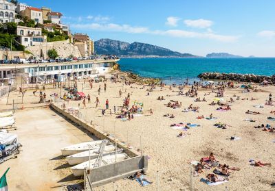 Menschen baden und sonnen sich am Plage du Prophète, einem Strand in Marseille