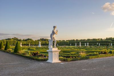 Barocker Großer Garten mit geometrisch angelegten Grünflächen, eingerahmt von weißen Statuen