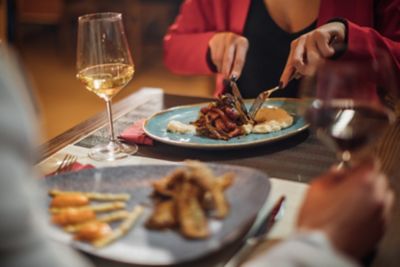 Couple enjoying a romantic dining experience with low lighting and wine