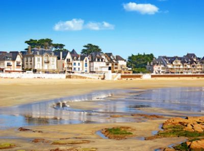 Marée basse sur la plage de Quiberon, bordée de maisons traditionnelles bretonnes, lors d’une journée ensoleillée