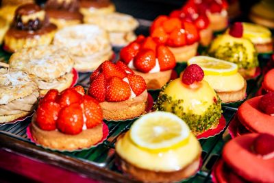 Verschiedene adrett drapierte kleine Törtchen in der Auslage einer Patisserie