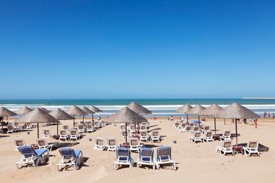 Atlantic Ocean beach in Agadir, Morocco with powder sand, sun loungers and woven umbrellas
