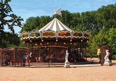Carrusel clásico con carpa a rayas y un Pegaso blanco en la cima, situado en un parque arbolado