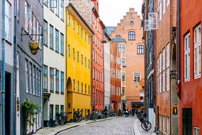 Tall, colourful buildings lining a cobbled Copenhagen street