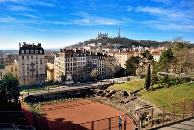 Remains of the Amphitheatre of the Three Gauls in Lyon, next to a tranquil building-lined street