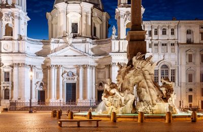 The Fontana dei Quattro Fiumi illuminated at night in Rome, Italy