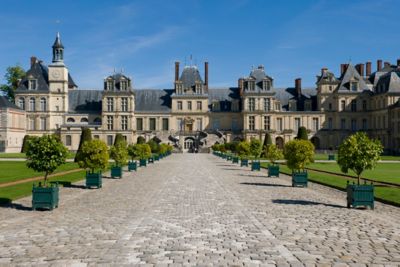 The broad, cobbled front path of stately Fontainebleau Castle in France
