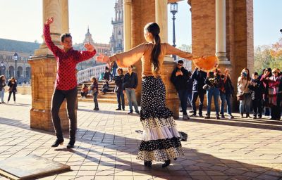 A pair of flamenco dancers performing in front of an audience in Plaza de España, Seville