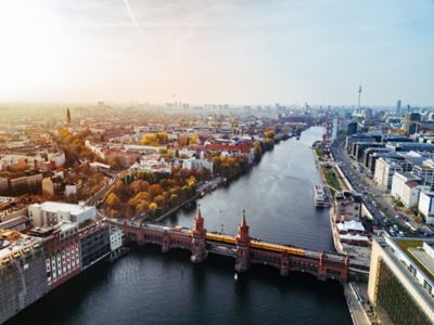 Die neugotische Oberbaumbrücke in Berlin mit gelber U-Bahn darauf und der Skyline im Hintergrund