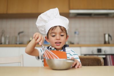 Enfant déguisé en chef cuisinier lors d'un atelier cuisine
