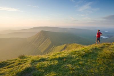 A hiker on the summit of Pen y Fan in Bannau Brycheiniog National Park, Wales
