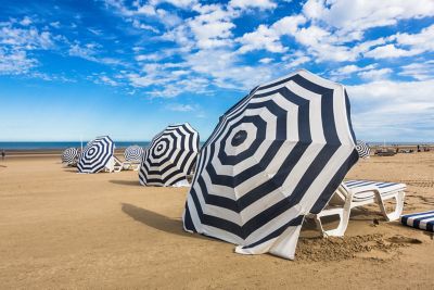 Striped blue-and-white umbrellas on wide De Panne beach, Belgium