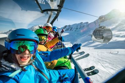 Frères et sœurs sur un télésiège lors d’un séjour au ski en famille