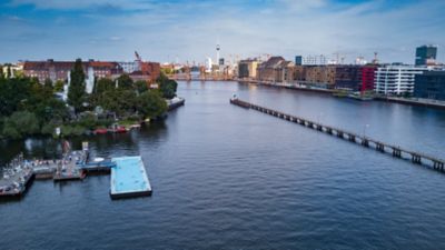 Das Badeschiff, ein schwimmender Pool in der Berliner Spree, mit Oberbaumbrücke im Hintergrund