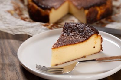 A thick wedge of delicious San Sebastián cheesecake on a plate