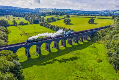 A steam train on a viaduct in the Gloucestershire countryside