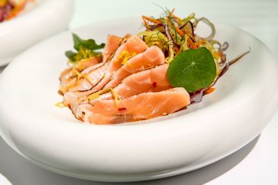 A Japanese-style seared salmon tataki salad in a fine dining setting