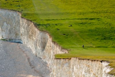 A cyclist near the Seven Sisters chalk cliffs in South Downs National Park