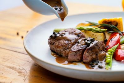An artfully arranged steak and colourful vegetables in a fine dining restaurant