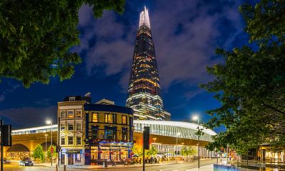 London Bridge station at night, with a cosy pub and the illuminated Shard building