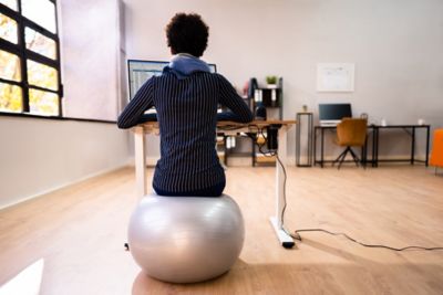 A business traveller sitting on an exercise ball while working in the office
