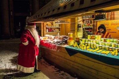 Santa perusing baked goods and honey at a Christmas market stall in Riga, Latvia