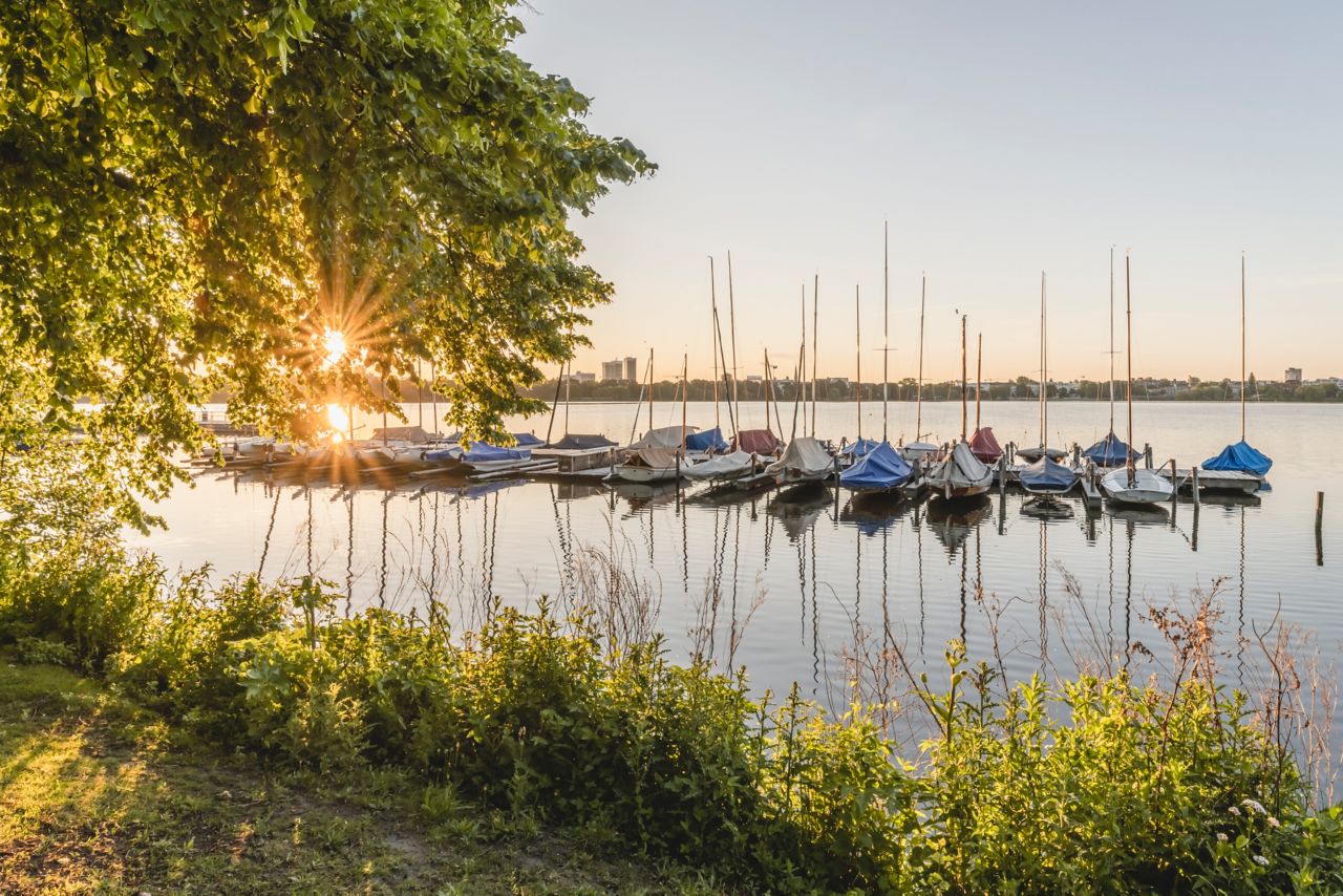 Segelboote an einem Steg in der Außenalster, einem schönen Ort in Hamburg, bei Sonnenaufgang