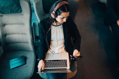 Une femme télétravaille dans le train, écoutant de la musique pour se concentrer