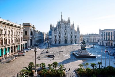 Piazza del Duomo en Milán, con la catedral y los edificios circundantes, bajo un cielo azul claro