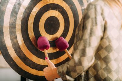 A therapist sounding a large gong during a healing session