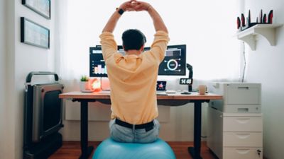 A business traveller practising active sitting at their desk