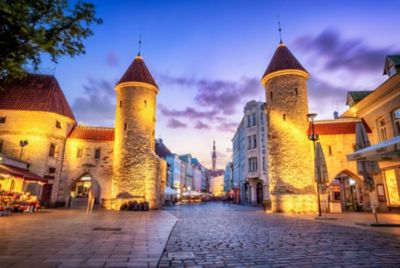 Tallinn's medieval Old Town, with stone gates and cobbled streets, lit up at night