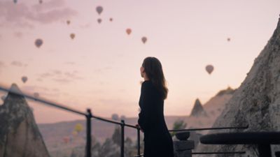 A traveller enjoying alone time watching hot-air balloons in the sky