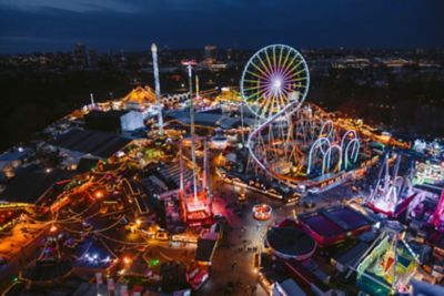 Bei Nacht beleuchtete Fahrgeschäfte auf dem Winter Wonderland im Hyde Park, London