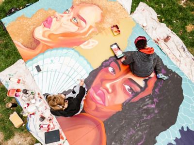 Femmes qui peignent une œuvre murale dans un parc