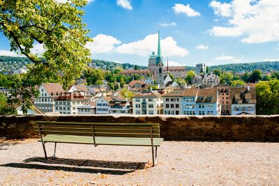 Ausblick von einer Bank im Lindenhof, einem erhöht liegenden Park, auf die Dächer von Zürich