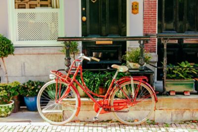 Vélo vintage rouge, déposé à l’entrée d’une habitation dans le quartier de Jordaan