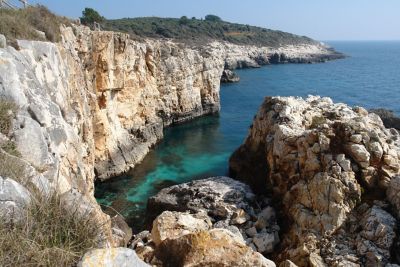 Rocky cliffs overlooking blue waters on Mala Kolombarica beach in Cape Kamenjak